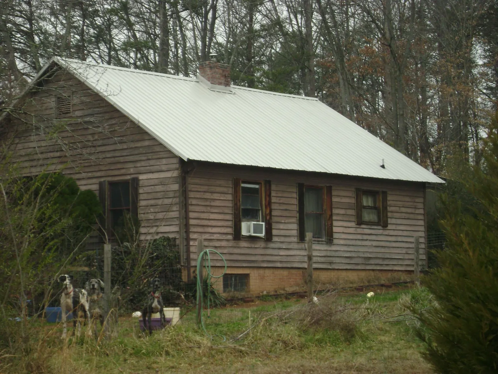 White metal roof on an old wood sided farmhouse, from a Asphalt Shingle Roof Repair job in Lake Helen